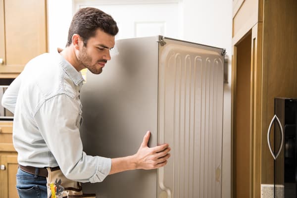 An appliance technician installing a refrigerator